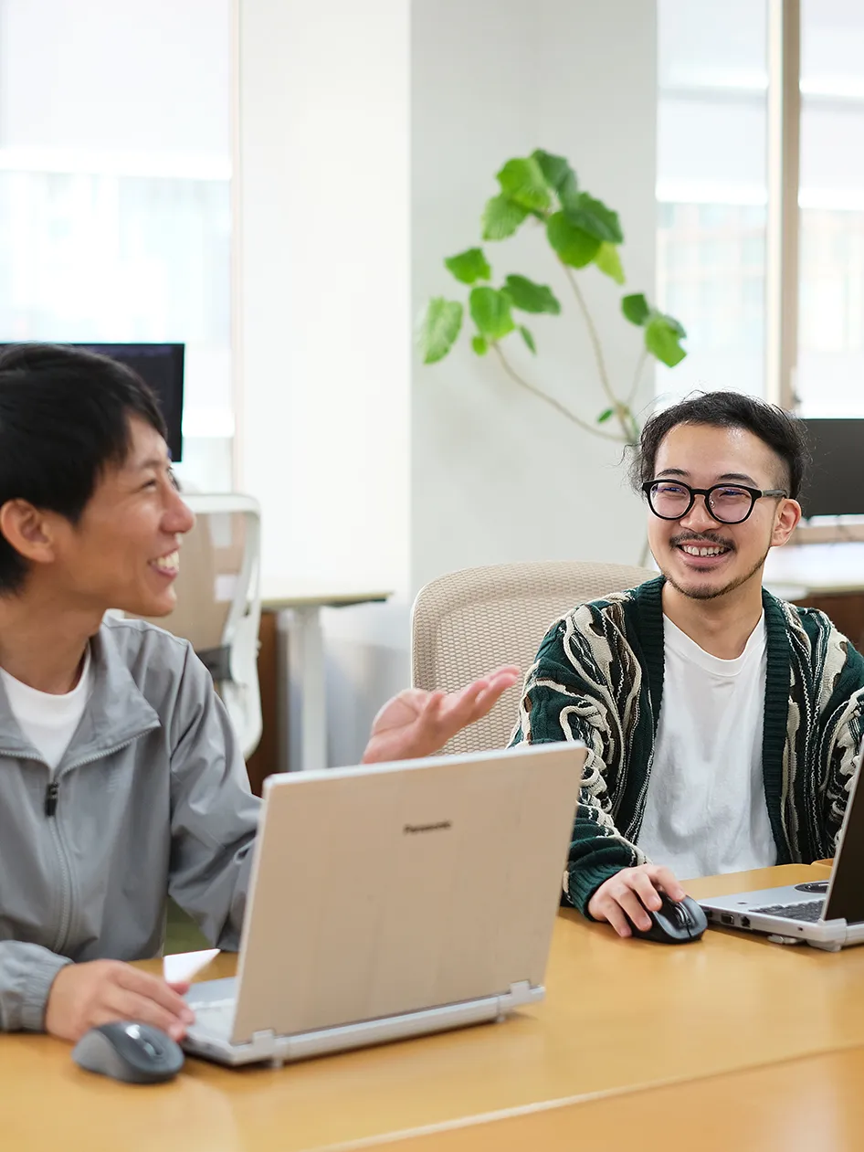 写真　社員二人が談笑しながら相談している様子